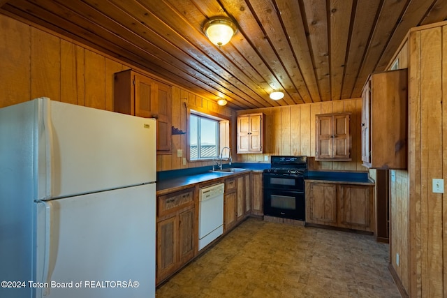 kitchen featuring white appliances, wood ceiling, sink, and wooden walls