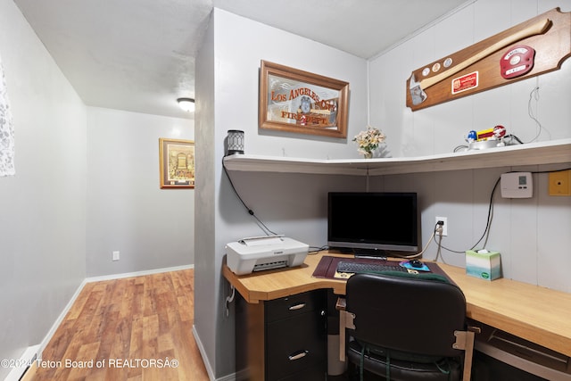 home office with light hardwood / wood-style floors and built in desk