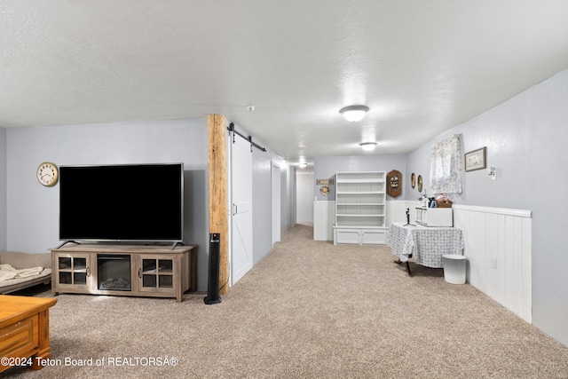 interior space featuring a barn door, carpet flooring, and a textured ceiling