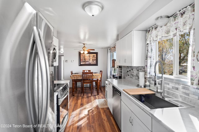 kitchen featuring dark hardwood / wood-style floors, sink, backsplash, appliances with stainless steel finishes, and white cabinetry