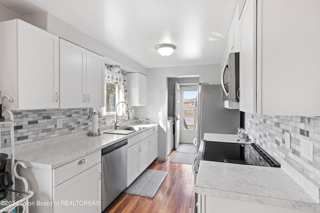 kitchen with plenty of natural light, appliances with stainless steel finishes, sink, and white cabinetry