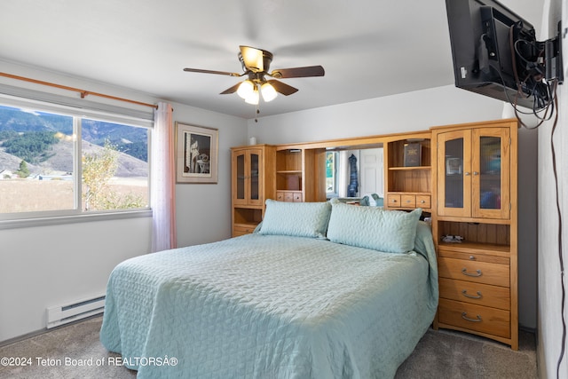 bedroom featuring ceiling fan, a baseboard radiator, and carpet flooring