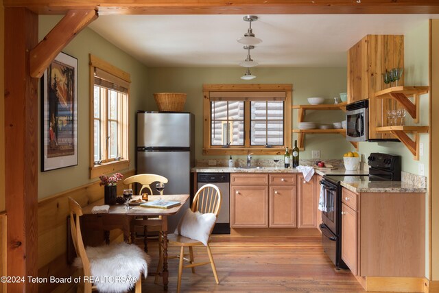 kitchen with light stone countertops, a healthy amount of sunlight, appliances with stainless steel finishes, and decorative light fixtures