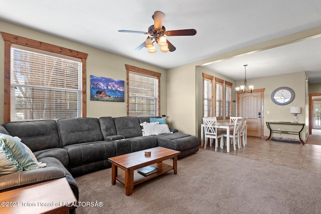 living room featuring ceiling fan with notable chandelier and light tile patterned floors