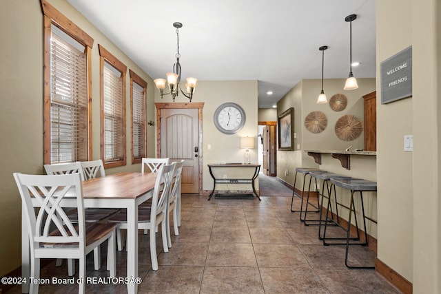 tiled dining space with an inviting chandelier