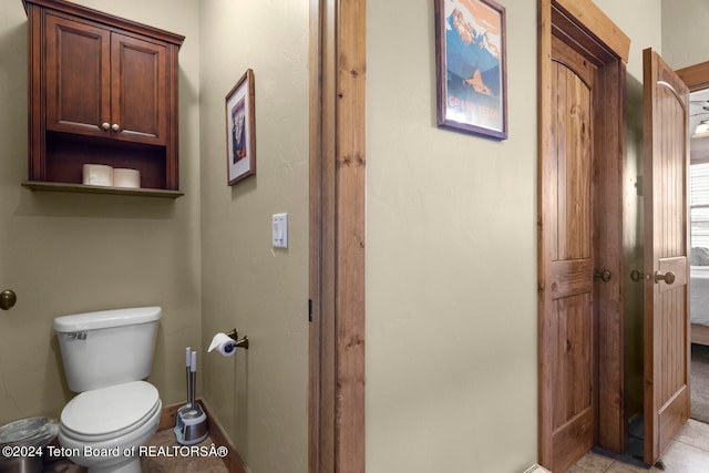 bathroom with toilet and tile patterned flooring