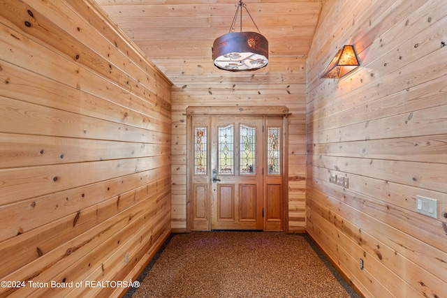 doorway with wood ceiling, wood walls, and carpet floors