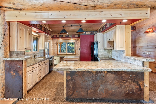 kitchen with tasteful backsplash, light stone counters, wood walls, black appliances, and sink