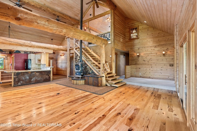 interior space with wood ceiling, hardwood / wood-style flooring, wooden walls, high vaulted ceiling, and ceiling fan