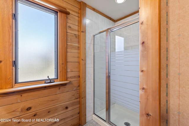 bathroom featuring wood walls and an enclosed shower