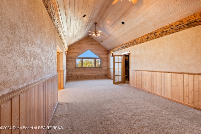 carpeted spare room with wood ceiling, wood walls, lofted ceiling, and ceiling fan