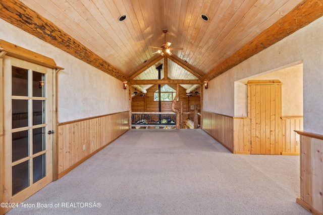 interior space with ceiling fan, wooden ceiling, wood walls, lofted ceiling with beams, and light colored carpet