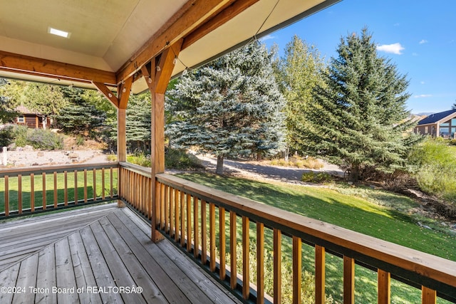 wooden deck featuring a lawn