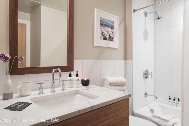 full bathroom featuring vanity, tiled shower / bath combo, and toilet