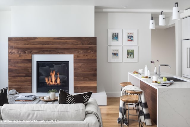 living room with light hardwood / wood-style flooring and sink