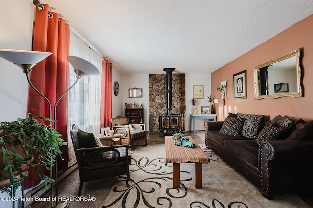 living room with a wood stove, a textured ceiling, and light colored carpet