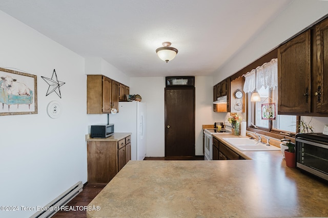 kitchen with sink, appliances with stainless steel finishes, a baseboard radiator, and kitchen peninsula