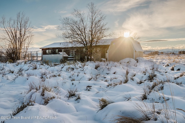 yard covered in snow featuring an outbuilding