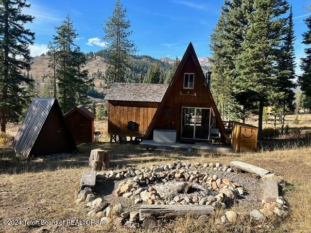 back of house with a storage unit and a mountain view