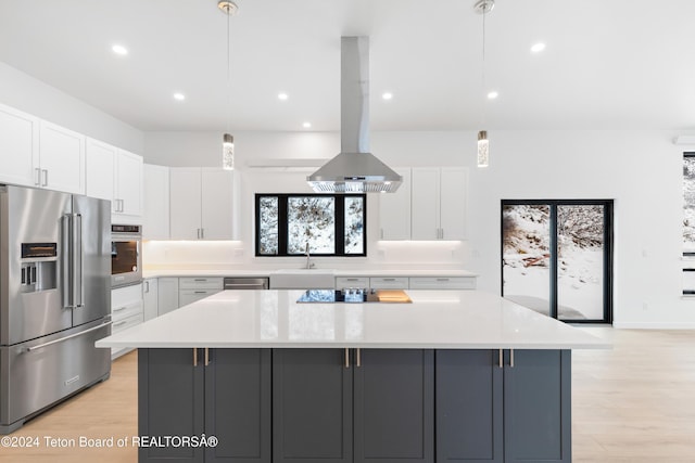 kitchen featuring white cabinets, sink, hanging light fixtures, appliances with stainless steel finishes, and island range hood