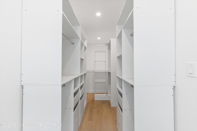 walk in closet with light wood-type flooring