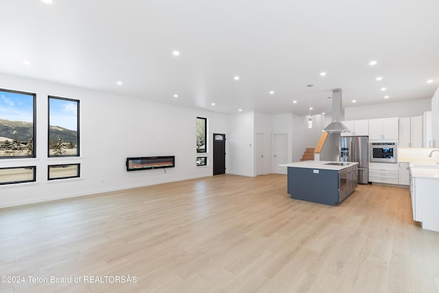 kitchen featuring a center island, stainless steel appliances, light hardwood / wood-style flooring, pendant lighting, and island range hood