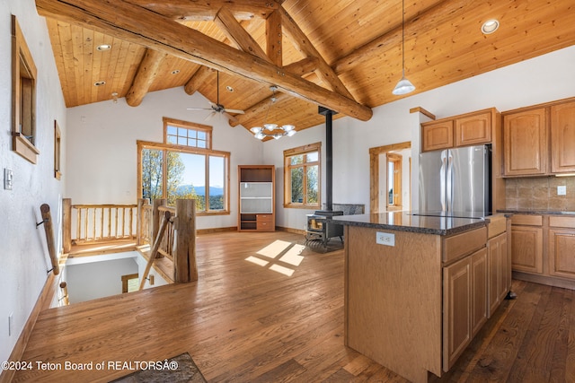 kitchen featuring wood ceiling, stainless steel fridge, dark wood-type flooring, a wood stove, and a center island