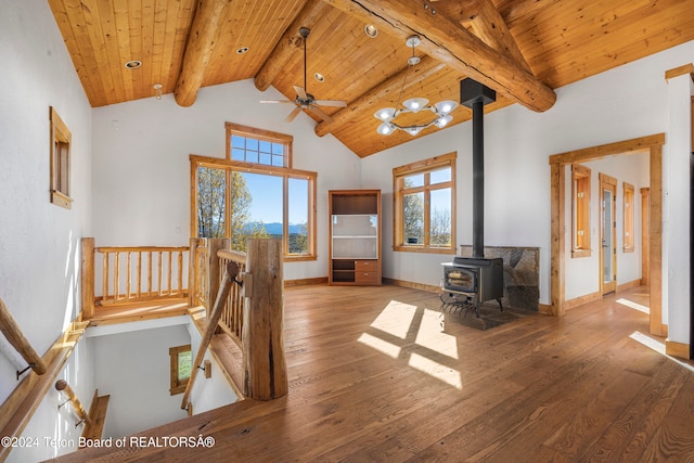 living room featuring hardwood / wood-style flooring, a wood stove, beamed ceiling, and wooden ceiling