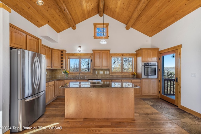 kitchen with beam ceiling, stainless steel appliances, dark wood-type flooring, and a kitchen island