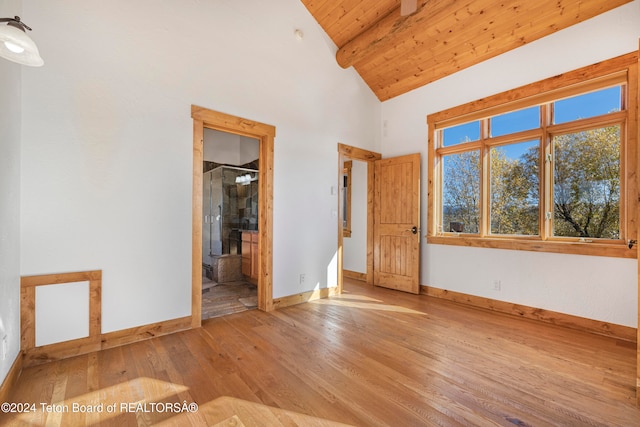 empty room featuring light hardwood / wood-style flooring, wood ceiling, and high vaulted ceiling