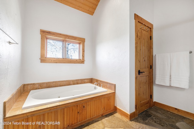 bathroom with a tub to relax in, wooden ceiling, and lofted ceiling