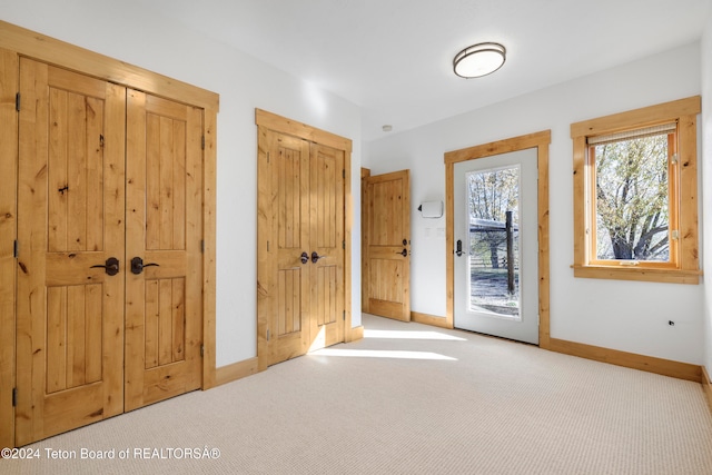 entryway with light colored carpet