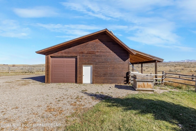 view of outbuilding featuring a rural view and a garage