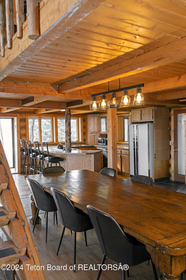 dining area with wood walls, beam ceiling, wooden ceiling, and light hardwood / wood-style flooring