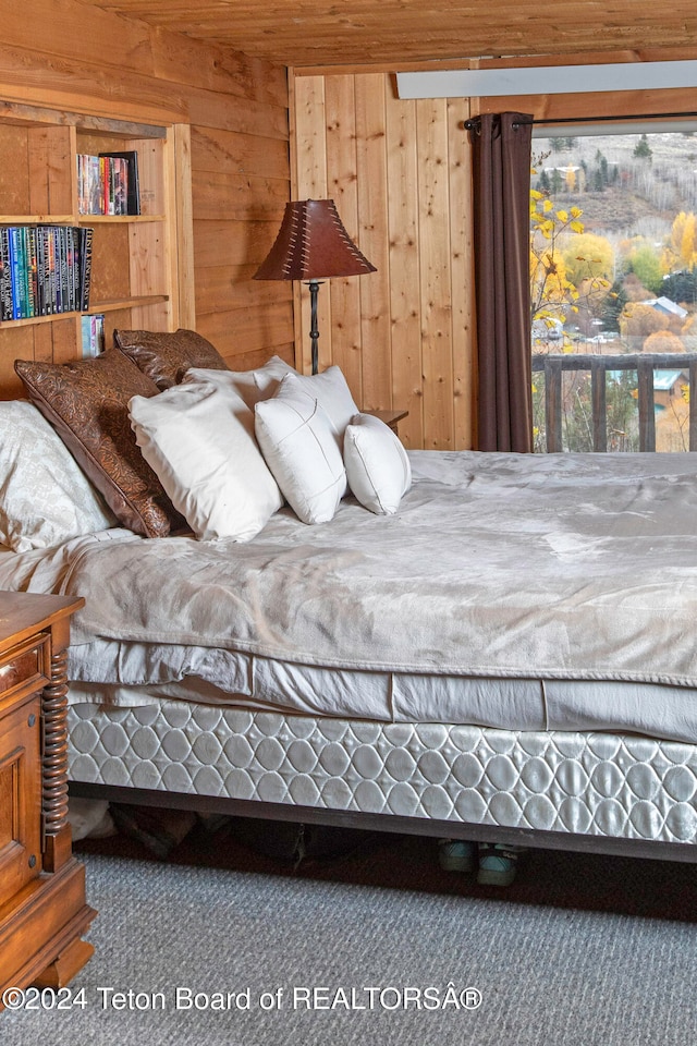 bedroom featuring carpet flooring and wooden walls