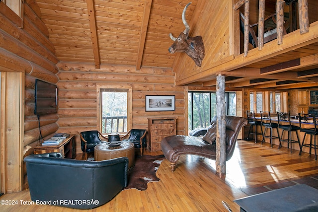 living room with rustic walls, hardwood / wood-style flooring, a healthy amount of sunlight, and wooden ceiling