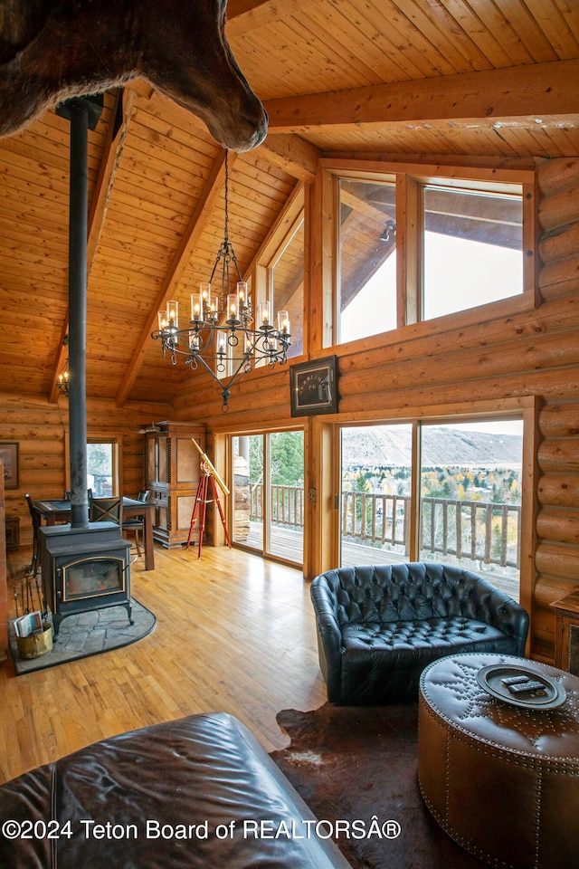 living room with wood ceiling, a wood stove, and a healthy amount of sunlight