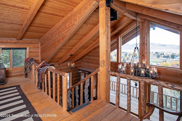 hallway featuring a wealth of natural light, an inviting chandelier, light hardwood / wood-style flooring, and vaulted ceiling with beams