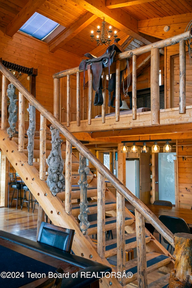 stairs featuring vaulted ceiling with skylight, a chandelier, wood ceiling, wood-type flooring, and wooden walls