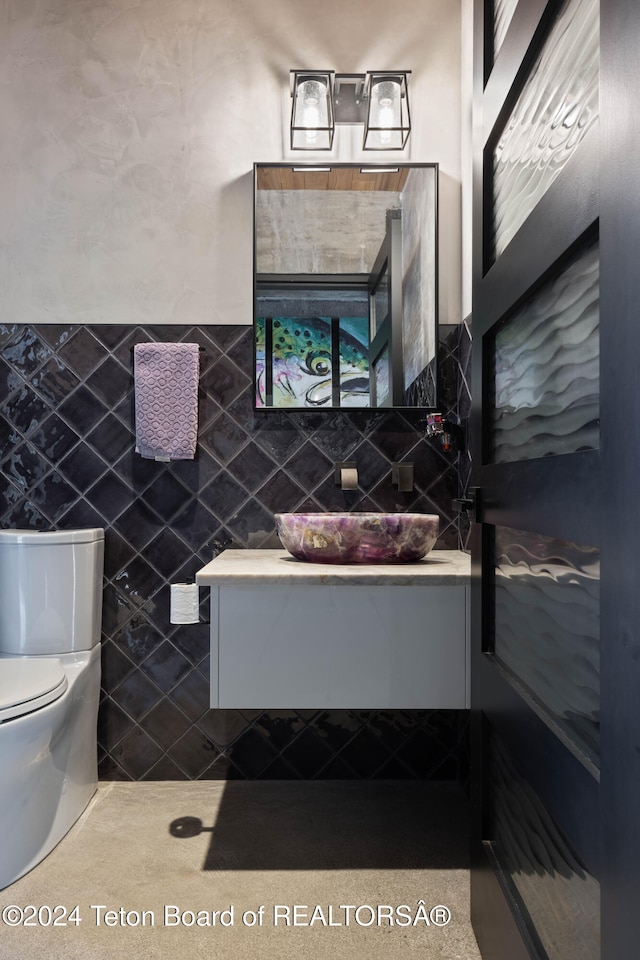 bathroom featuring tile walls and toilet