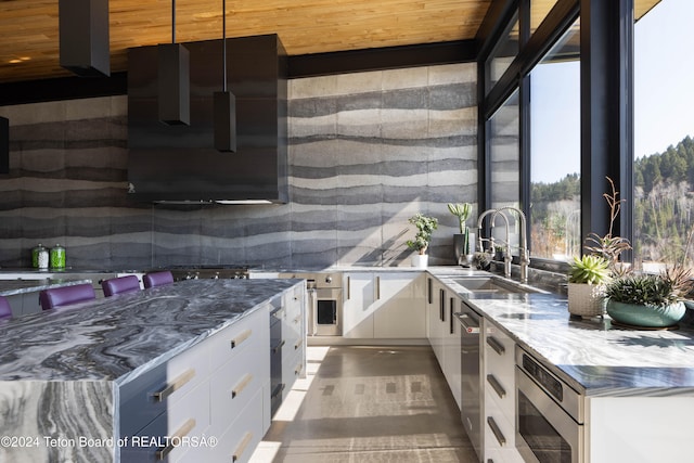 kitchen featuring sink, pendant lighting, wooden ceiling, dark stone countertops, and white cabinetry