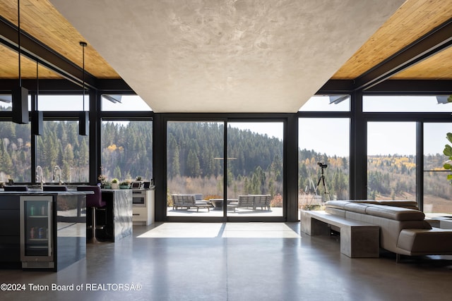 unfurnished sunroom featuring a wealth of natural light and beverage cooler