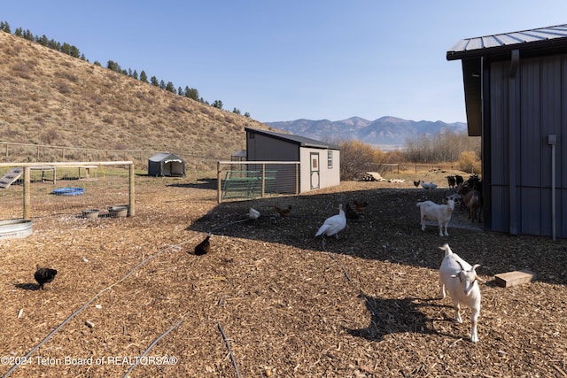 view of yard with a mountain view, an outbuilding, a rural view, and a playground