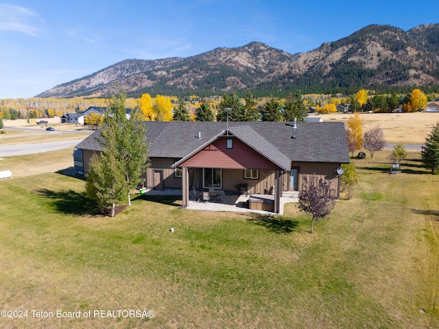 exterior space with a lawn, a mountain view, and a patio