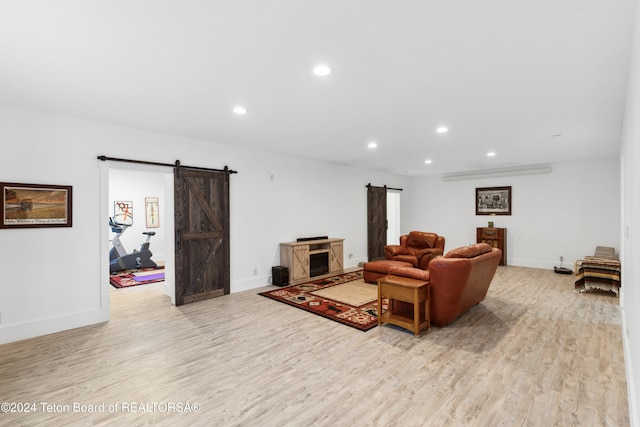 living room featuring a barn door and light wood-type flooring