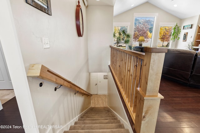 stairs featuring lofted ceiling and hardwood / wood-style flooring