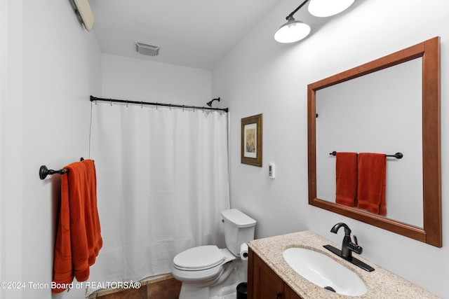 bathroom with toilet, vanity, and walk in shower