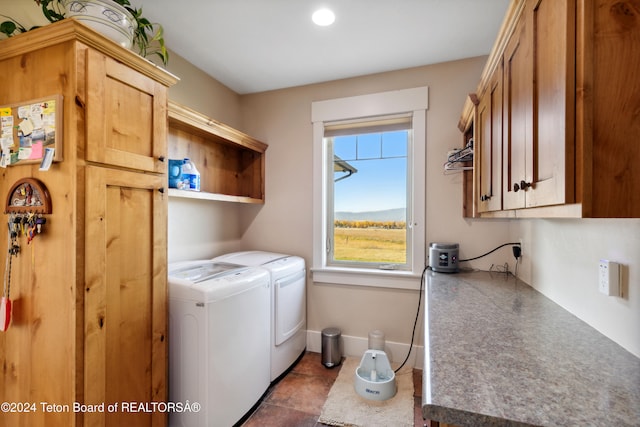 laundry room featuring cabinets, separate washer and dryer, and dark tile patterned floors