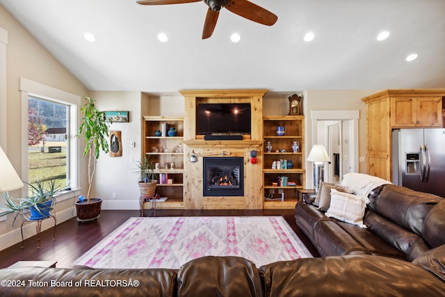 living room with dark wood-type flooring, ceiling fan, and vaulted ceiling