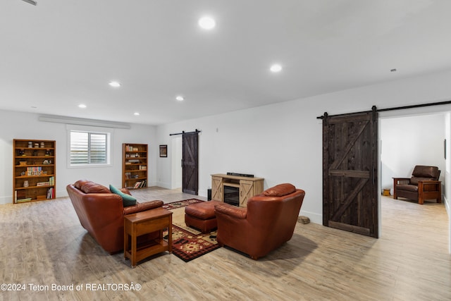 living room featuring light wood-type flooring and a barn door